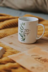 Enjoy a tranquil morning with this motivational coffee mug on a cozy blanket, perfect for peaceful reflection.